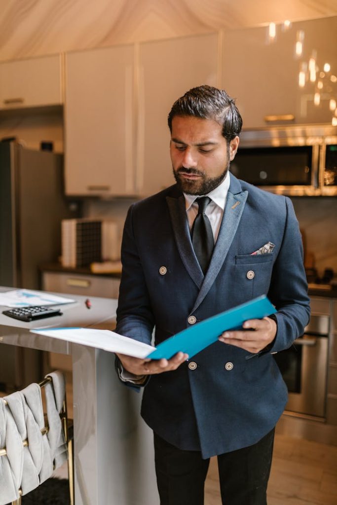 A Man in Blue Suit Jacket Reading a Document